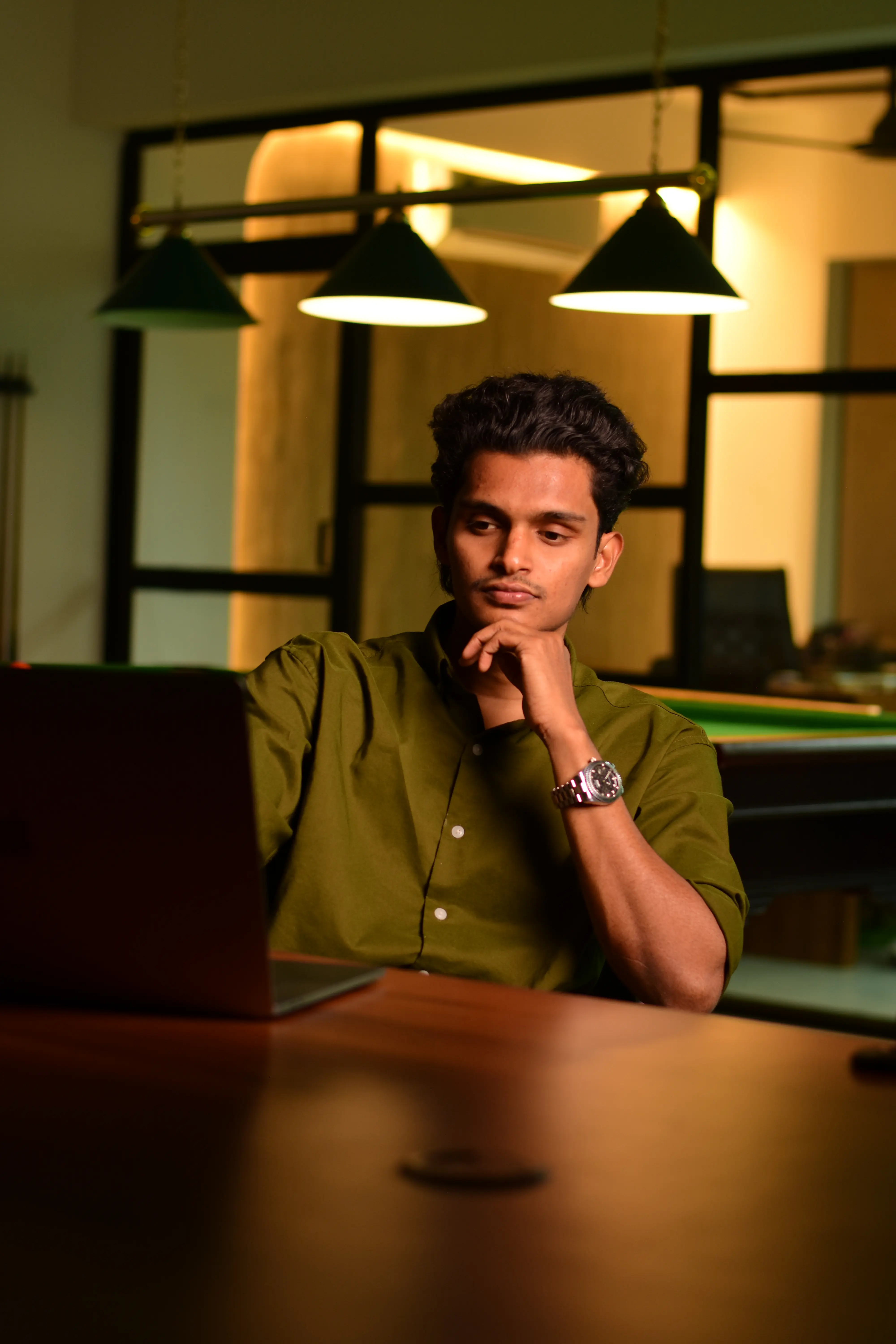 Ajmal working on a laptop in a modern office setting